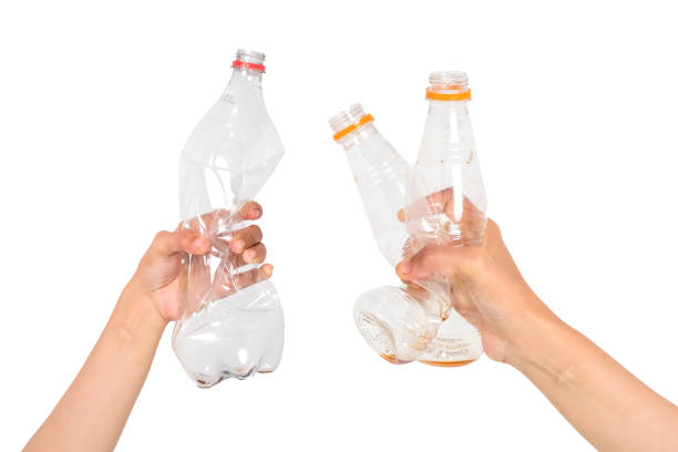 istock Crumpled plastic bottle trash isolated in human hand on white background, Environmental pollution 1494279440