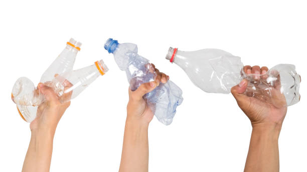 istock Crumpled plastic bottle trash isolated in a human hand on white background 1494279688