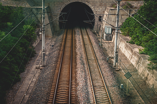 Train on a railway through a tunnel in an idyllic landscape