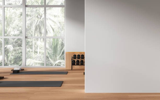 istock Stylish yoga class interior with mat and dumbbell rack, mock up wall 1494280124