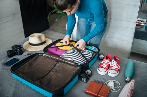 Woman neatly packing her suitcase ready for a vacation.