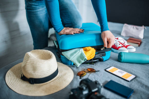 istock Woman struggling with closing her suitcase. 1494280439