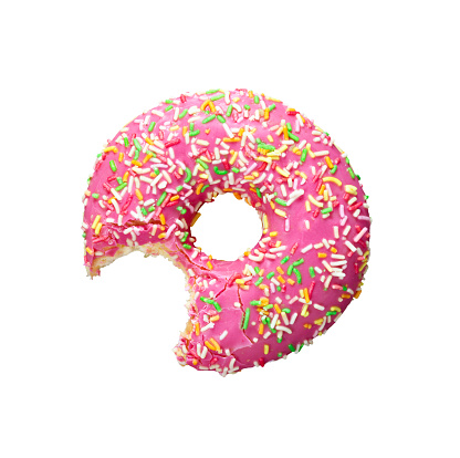 Closeup view of one bite missing of donut with pink frosting and colorful sugar sprinkles isolated on white background