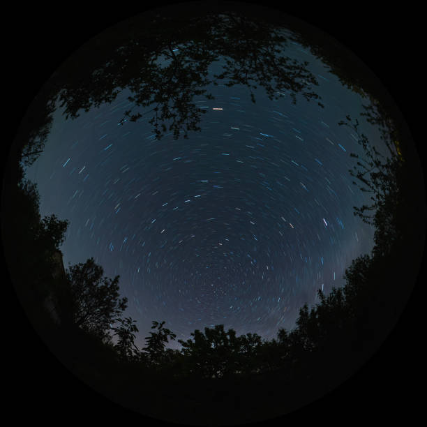 Star trails in the form of lines in the night sky with a long exposure stock photo