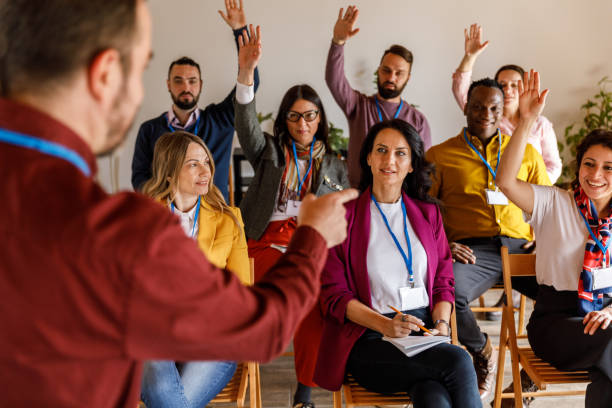 Group of people raising their hands to ask questions during a presentation or a meeting stock photo