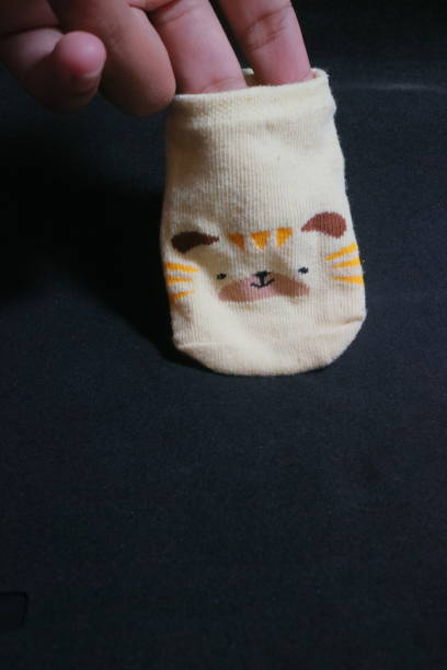 istock Cute baby socks yellow with a hamster face on them 1494282793