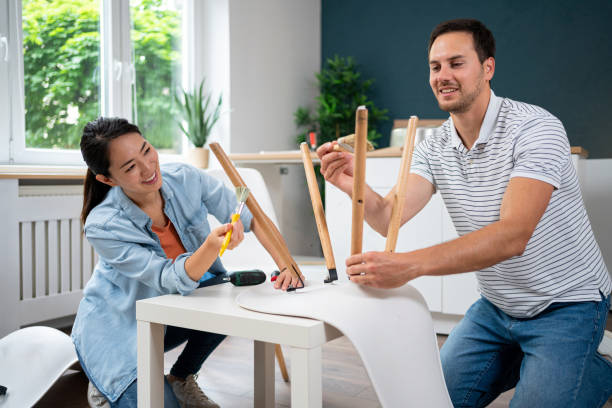 joven pareja multirracial juntos barnizando los caballetes de la silla - home improvement couple painting real estate fotografías e imágenes de stock