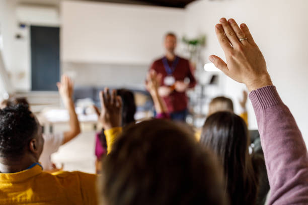 Group of people raising their hands to ask questions during a presentation or a meeting stock photo