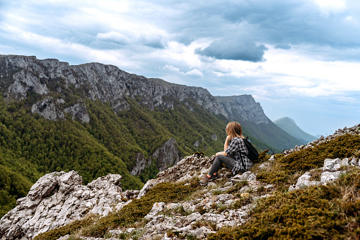 Young casually clothed female hiker enjoying view while hiking