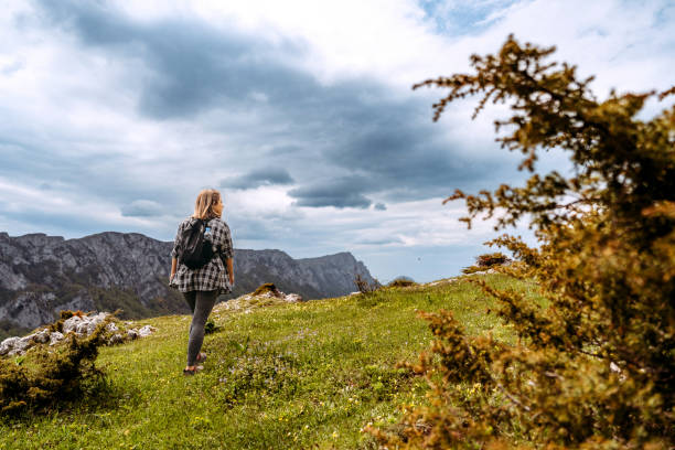 istock Woman hiking on mountain against cloudy sky 1494287126