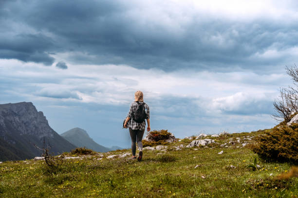 istock Woman hiking on mountain against cloudy sky 1494287128