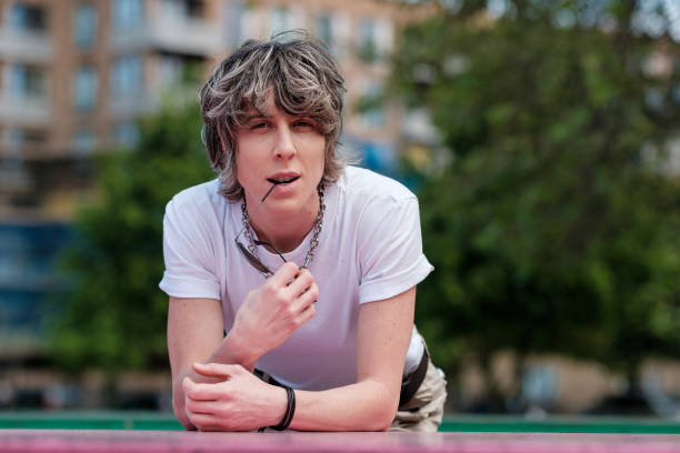 Androgynous non-binary person looking at camera outdoors.
