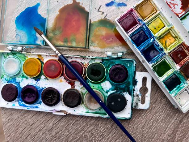 Artists palettes of paints with a paintbrush. Looks messy and well used