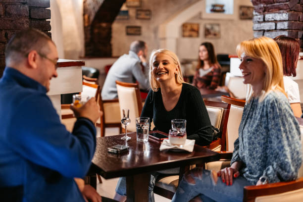 istock Group Of Mid Adults Relaxing In A Bar 1494290730