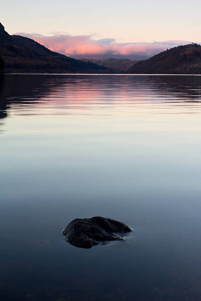 istock single rock in calm lake scene. 149429217
