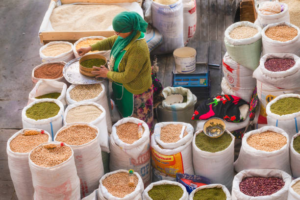 Khujand, Tajikistan . October 17, 2019: Grain seller woman at the Panchshanbe bazaar. The Panchshanbe bazaar is one of the largest bazaars in Central Asia.