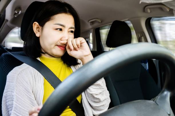 primer plano de una mujer asiática insatisfecha conduciendo un automóvil, frustrada por un vehículo maloliente - car freshner fotografías e imágenes de stock