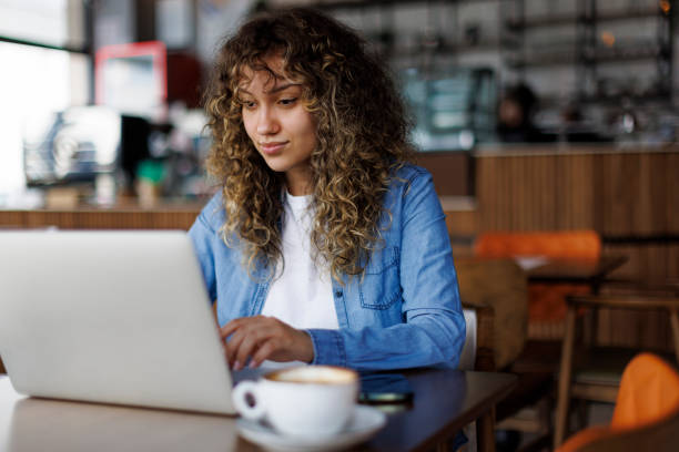 istock Young woman working on laptop at a cafe 1494296009