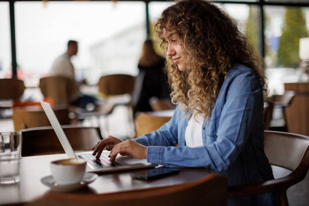 istock Young woman working on laptop at a cafe 1494296061