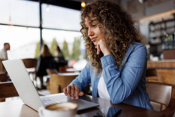 istock Young woman working on laptop at a cafe 1494296089