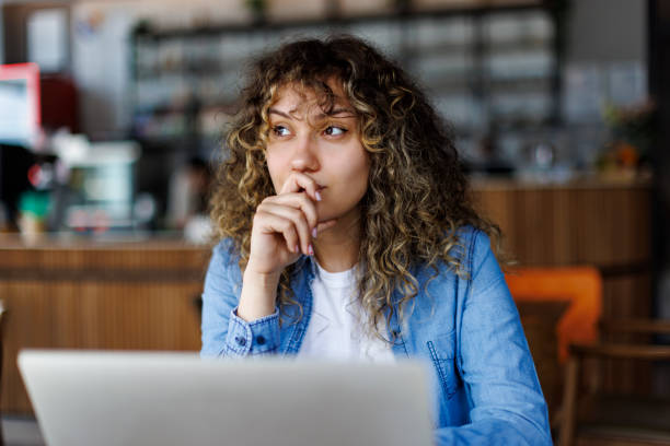 Young smiling woman working on laptop at a cafe stock photo