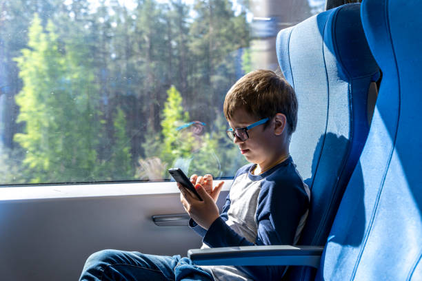 istock a cute Caucasian school-age boy with glasses rides a commuter train 1494298676