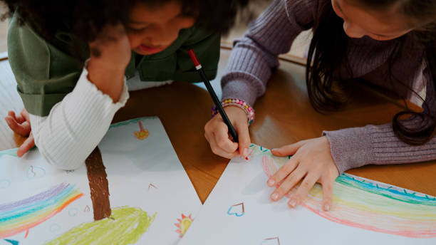 istock Two Little Schoolgirls Drawing Picture Together During Creativity Class. 1494310207