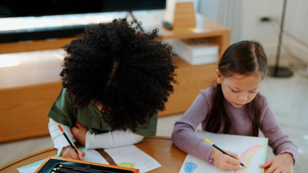 istock Two Little Schoolgirls Learning Art with Colored Pencils in Creativity Class at School. 1494310234