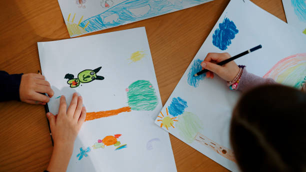 istock Two Little Schoolgirls Learning Art with Colored Pencils in Creativity Class at School. 1494310242