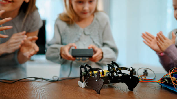 istock Young Schoolgirl Controlling Electronic Robot Under Teacher's Guidance. 1494311022