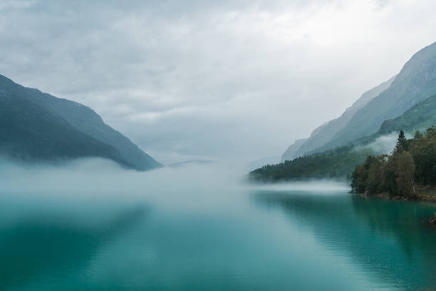 malerische aussicht auf den see in norwegen in nebel bedeckt - mountain mountain range norway fjord stock-fotos und bilder