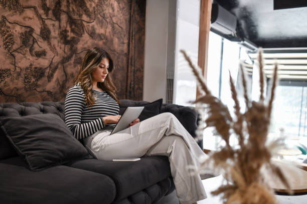 istock Gorgeous Female Freelancer Working On Digital Tablet While Sitting On Home Sofa 1494312597