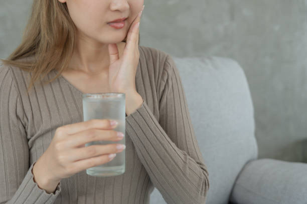 istock Asian woman feel sensitive teeth after drinking cold, female suffer tooth, decay problems, dental care, tooth extraction, decay problem, bad breath, Gingival Recession, Oral Hygiene instruction 1494314364