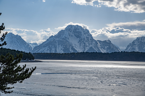View of  Moran and other peaks at icy Jackson Lake in the Yellowstone Ecosystem in western USA, North America.