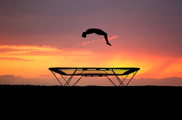 trampoline silhouette silhouetted teenager jumping on trampoline in sunset trampoline stock pictures, royalty-free photos & images