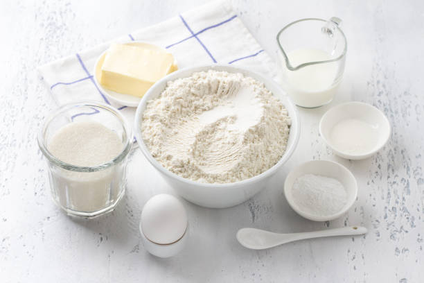 istock Ingredients: flour, sugar, butter, egg, milk, vanilla sugar, baking powder, salt on a light blue background for delicious homemade baking 1494320351