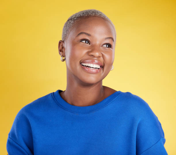 istock Thinking, smile and a black woman on a yellow background in a studio feeling nostalgic. Face, idea and happy with an attractive young female looking for inspiration while contemplating a thought 1494324553