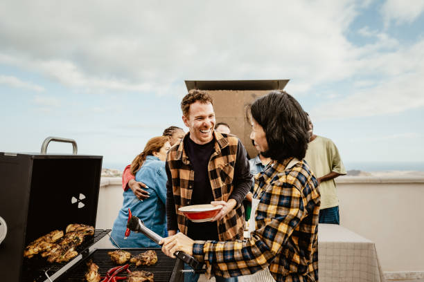 glückliche mehrgenerationenmenschen, die spaß beim grillen auf dem hausdach haben - sommertreffen und essenskonzept - white meat grilled barbecue chicken stock-fotos und bilder