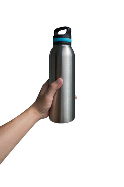 Hand holding stainless steel water bottle isolated on white background.