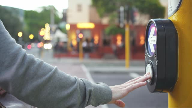 Woman pressing a button and crossing a busy city intersection