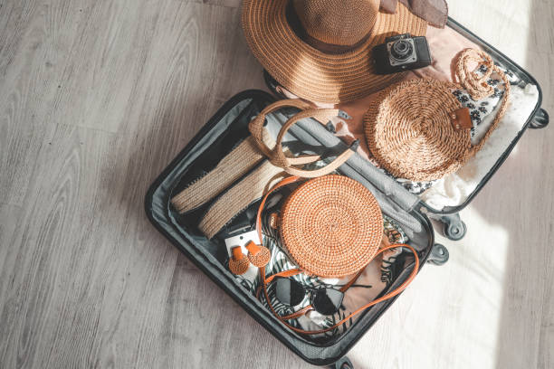 istock Suitcase with clothes, hat and camera on wooden background, top view 1494325536