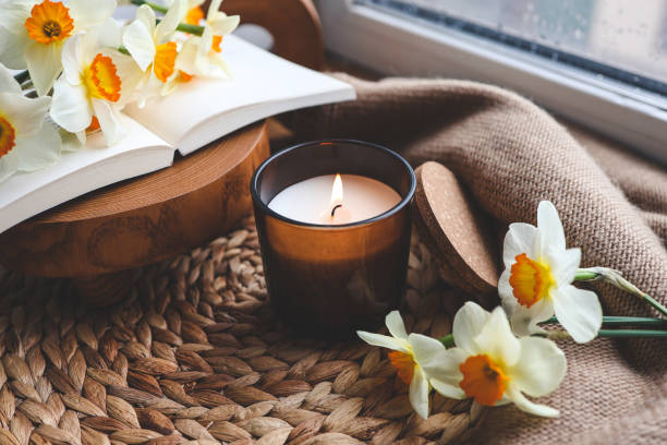 Bougie et jonquilles sur le rebord de la fenêtre, composition printanière - Photo