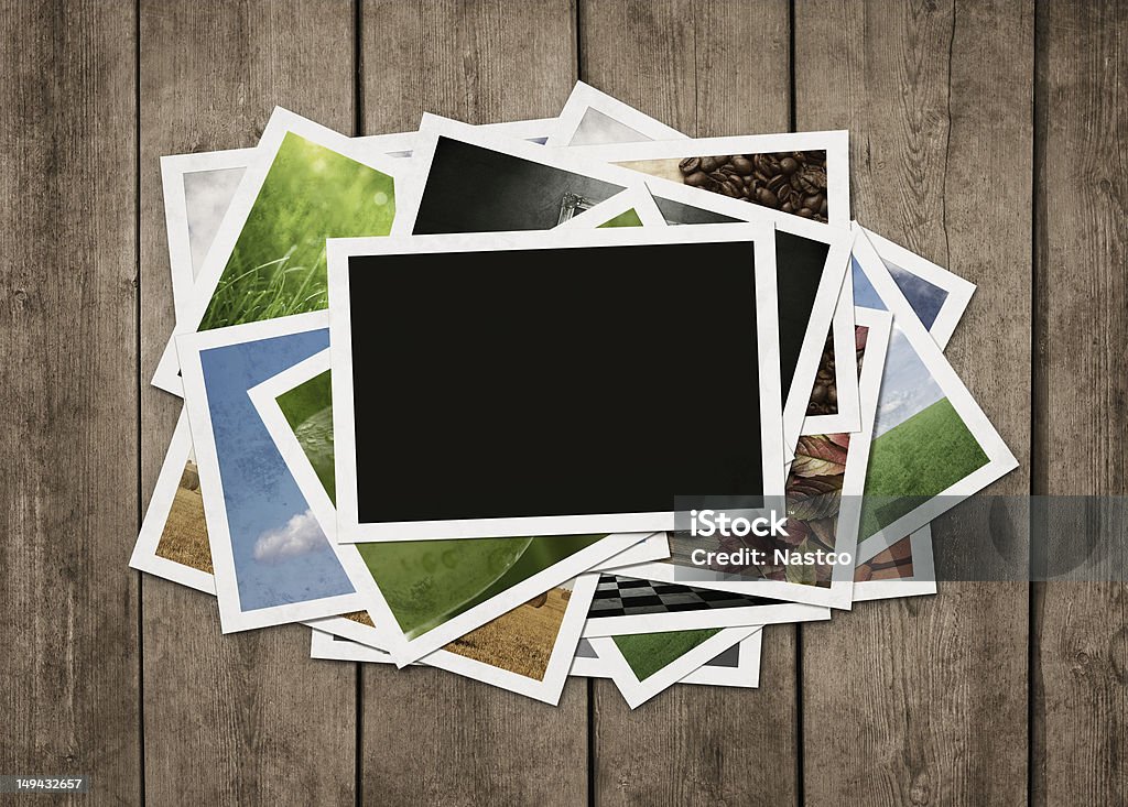 Stack of photos at wooden background Stack of old photographs at grunge wooden background with clipping path for the blank one Photograph Stock Photo