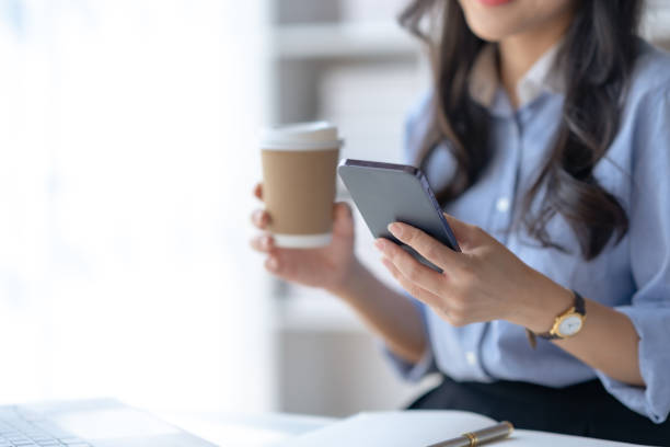 istock Close-up of a woman using a smartphone to work on various application including mobile transaction to send messages, LINE, and various business information sent via social media. 1494331296