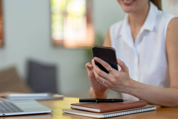 istock Close-up of a woman using a smartphone to work on various application including mobile transaction to send messages, LINE, and various business information sent via social media. 1494331831