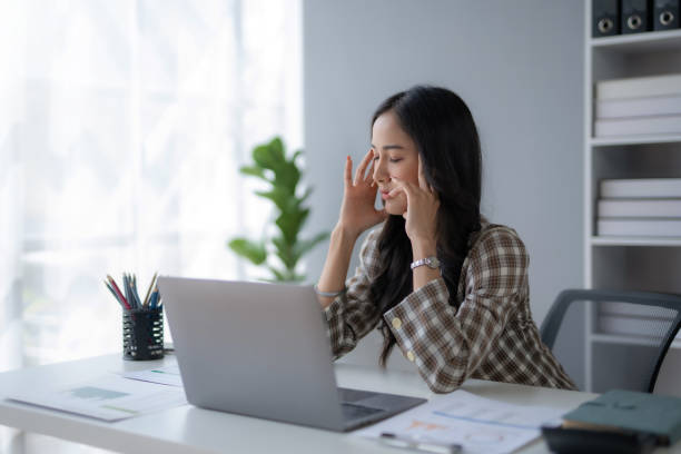istock Young Asian businesswoman worried about problem at work and stressed with laptop computer at office. 1494331837