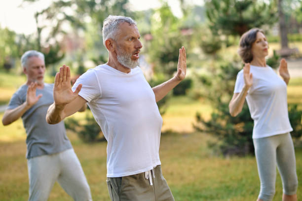 Mature group of people workout and practice tai chi.