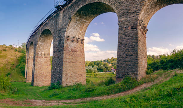 Stone railway ancient arch bridge over green valley