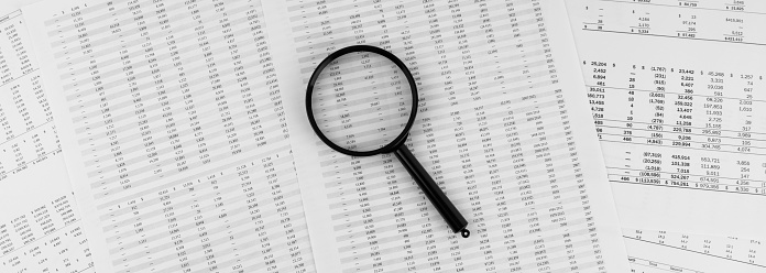 Magnifying glass on financial statement.
