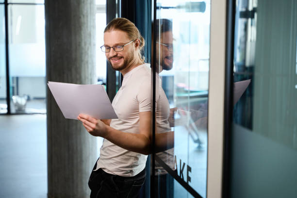 istock Caucasian man smiling while standing in modern room 1494342613